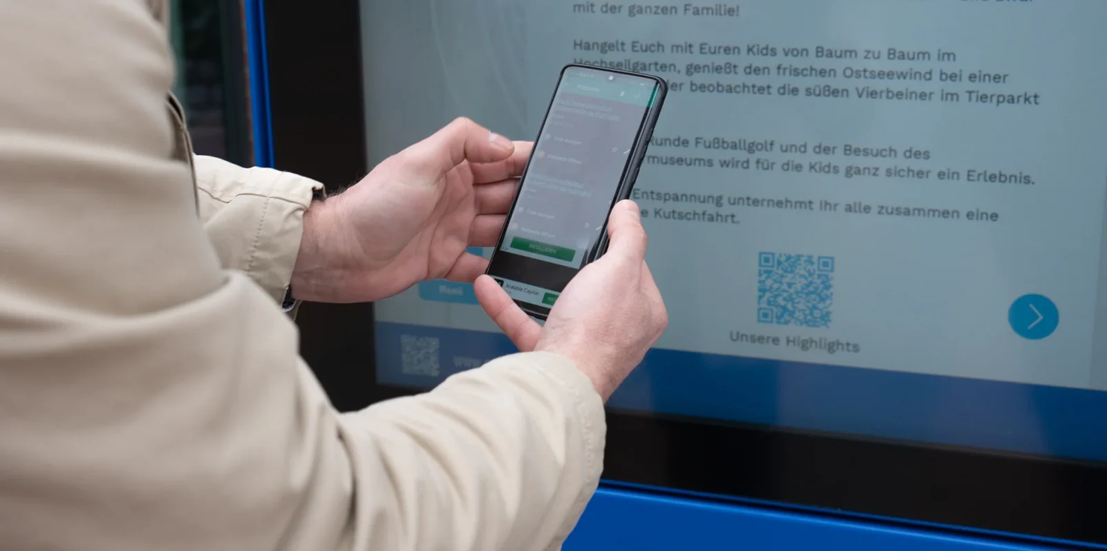 Mann scannt QR Code von Stele
