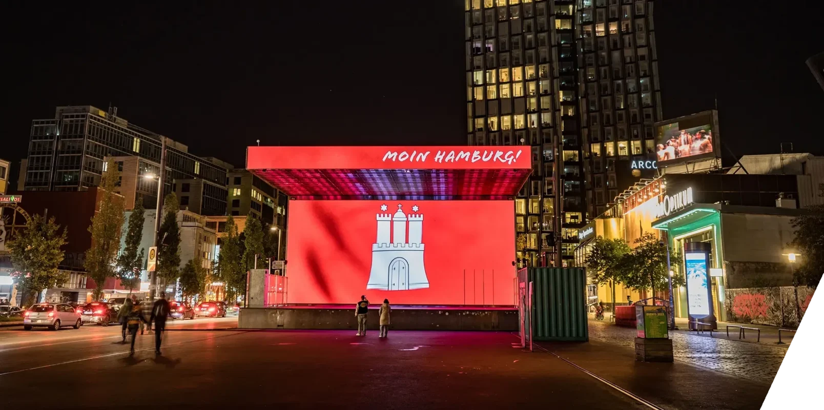 Auf der großen LED-Bühneninstallation auf dem Spielbudenplatz in Hamburg wird das Hamburger Wappen vor rotem Hintergrund und dem Schriftzug ‚Moin Hamburg‘ angezeigt.