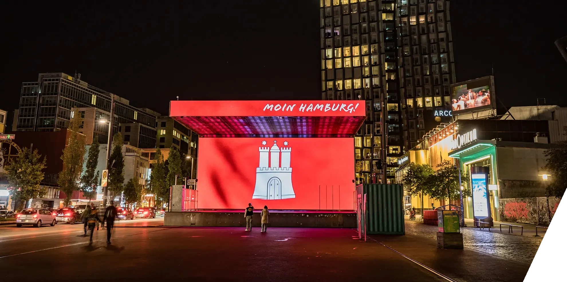 Auf der großen LED-Bühneninstallation auf dem Spielbudenplatz in Hamburg wird das Hamburger Wappen vor rotem Hintergrund und dem Schriftzug ‚Moin Hamburg‘ angezeigt.