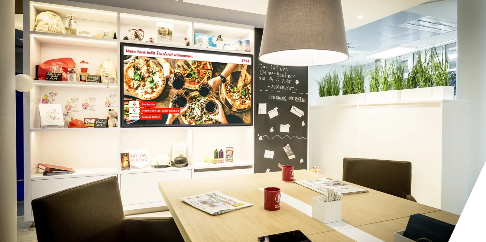 A screen in a Hamburg-based Sparkasse branch displays neighborhood-specific content for local customers.