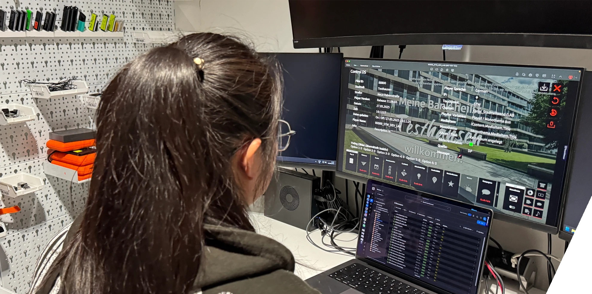 In a workshop, you can see a woman from the technical team working on software.